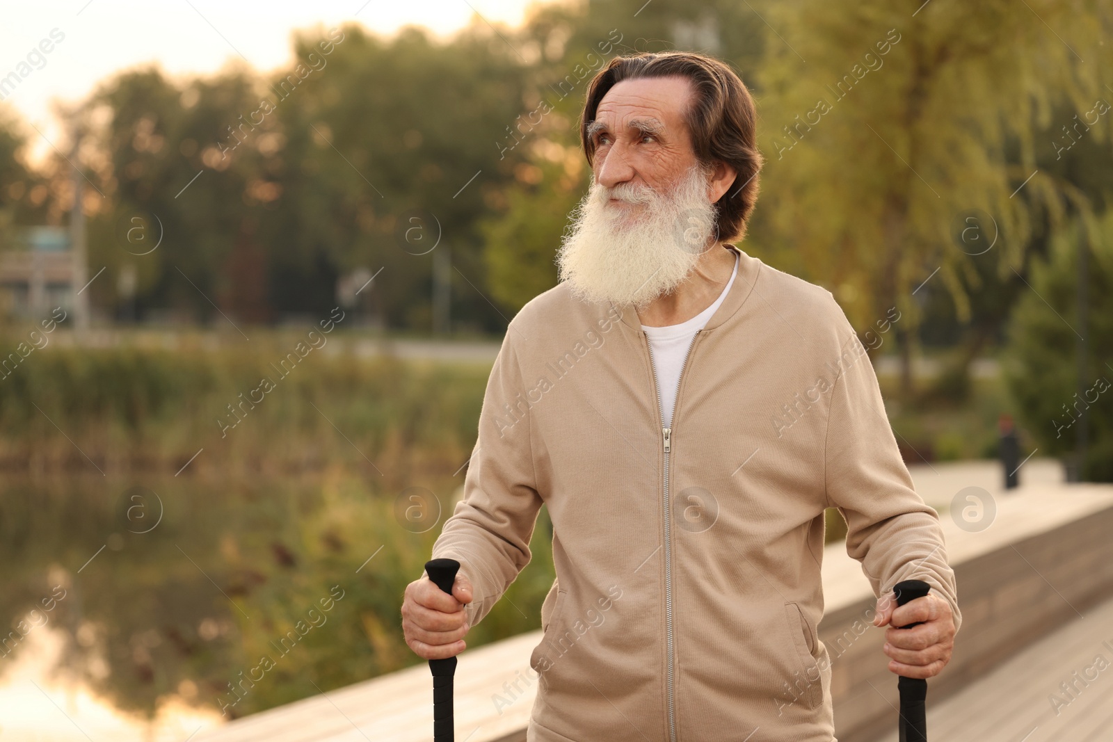 Photo of Senior man with Nordic walking poles outdoors