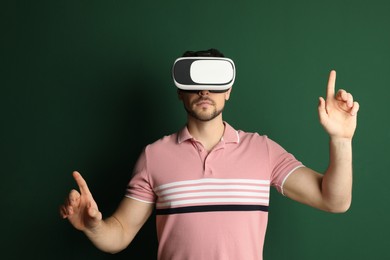 Photo of Man using virtual reality headset on green background