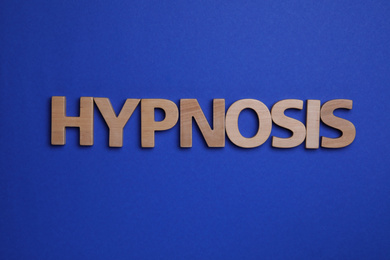Word HYPNOSIS made with wooden letters on blue background, flat lay