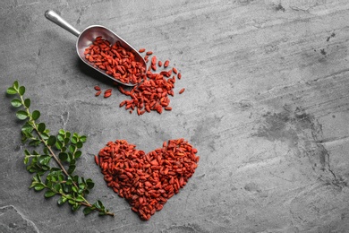 Flat lay composition with dried goji berries on grey table, space for text. Healthy superfood