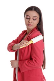 Photo of Young woman cleaning clothes with lint roller on white background