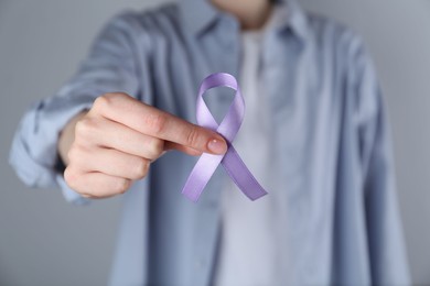 Photo of Woman with violet awareness ribbon on grey background, closeup