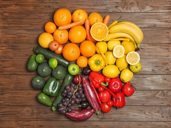 Photo of Rainbow composition with fresh vegetables and fruits on wooden background, flat lay