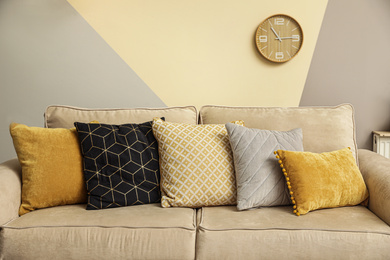 Pillows on modern sofa indoors. Stylish room interior decor