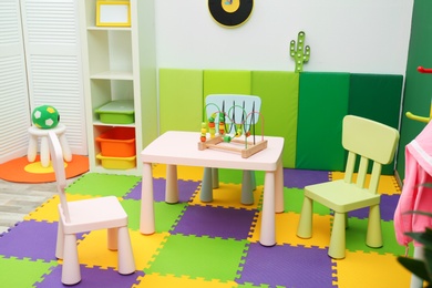 Stylish playroom interior with table and chairs