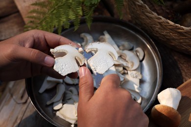 Photo of Man slicing mushrooms at table, closeup view