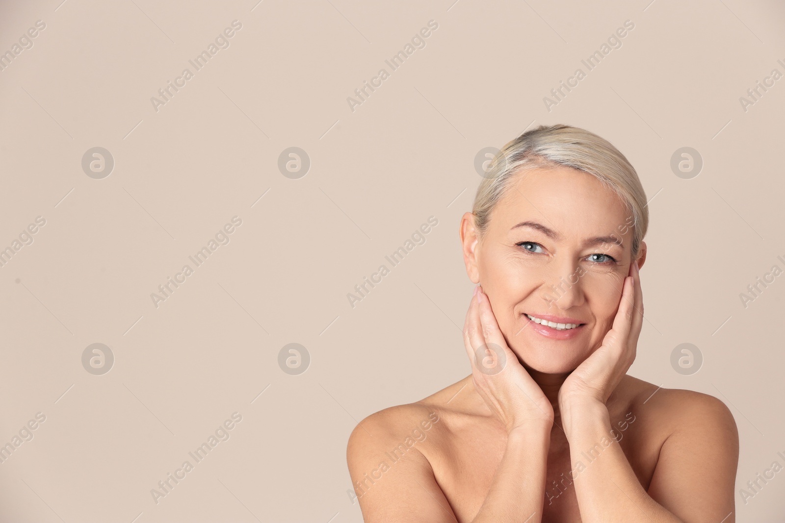 Photo of Portrait of beautiful mature woman on beige background. Space for text