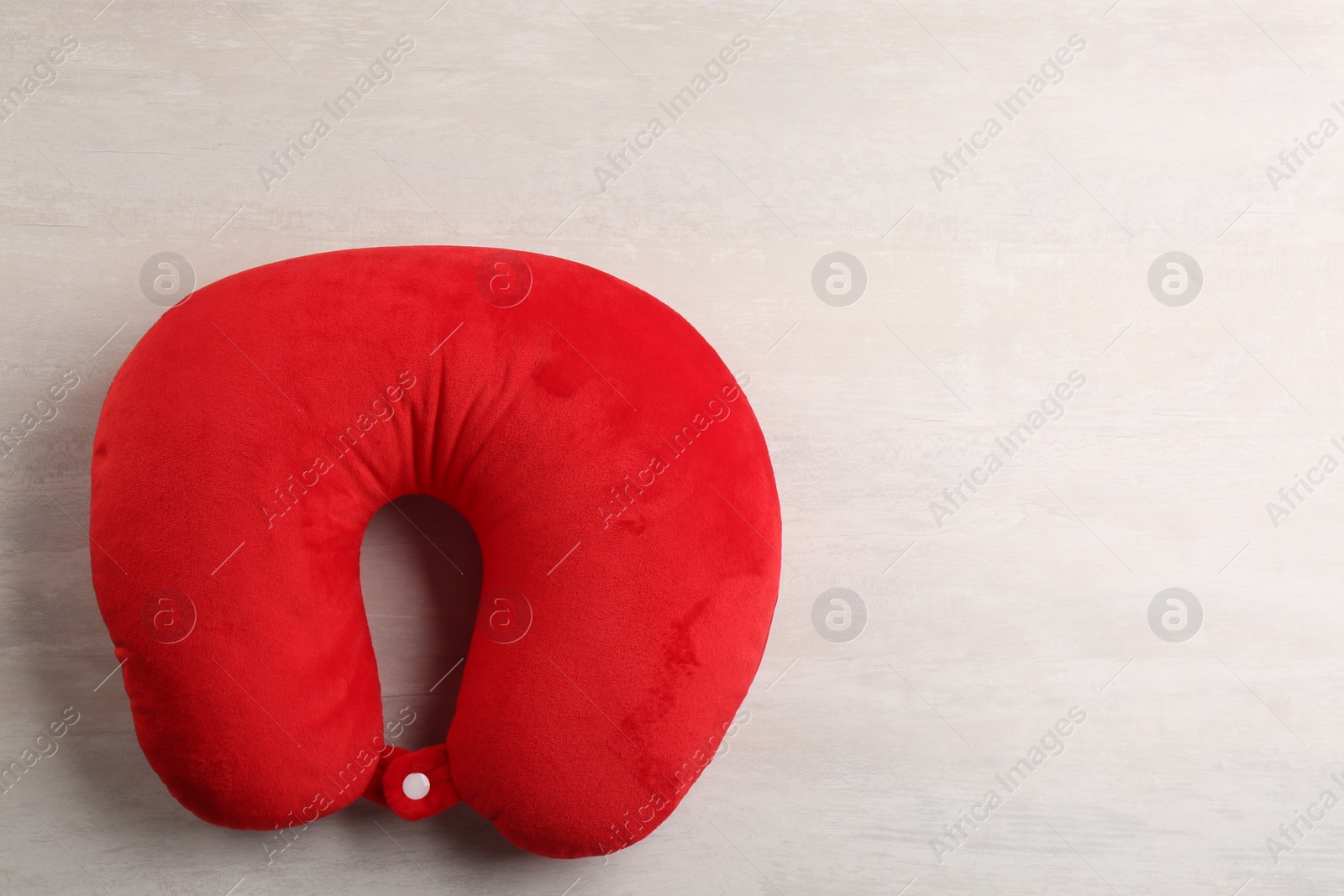 Image of Red travel pillow on light background, top view. Space for text