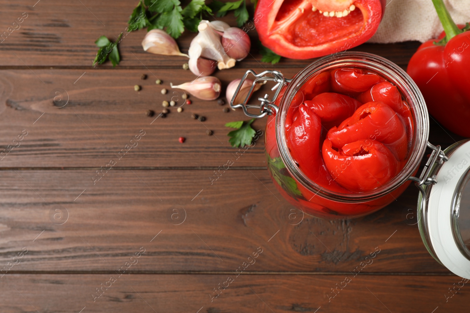 Photo of Glass jar with pickled peppers on wooden table, flat lay. Space for text