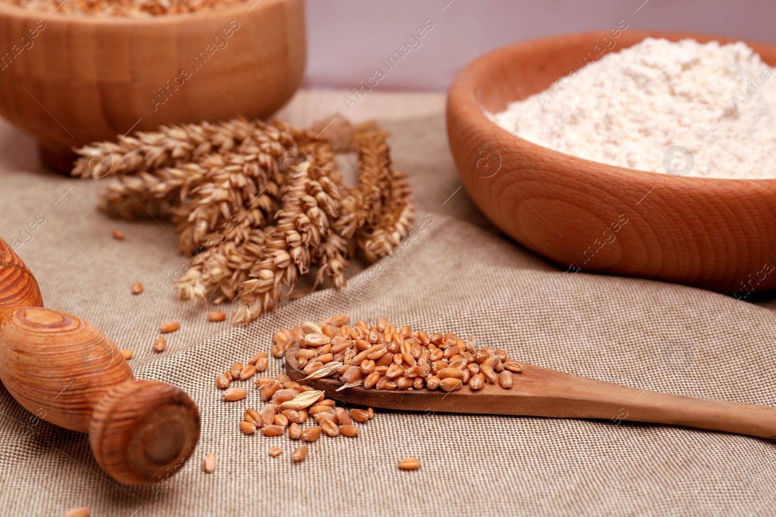 Photo of Wheat grains, flour and spikelets on cloth