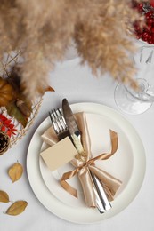 Photo of Beautiful autumn place setting with blank card and decor for festive dinner on table, flat lay