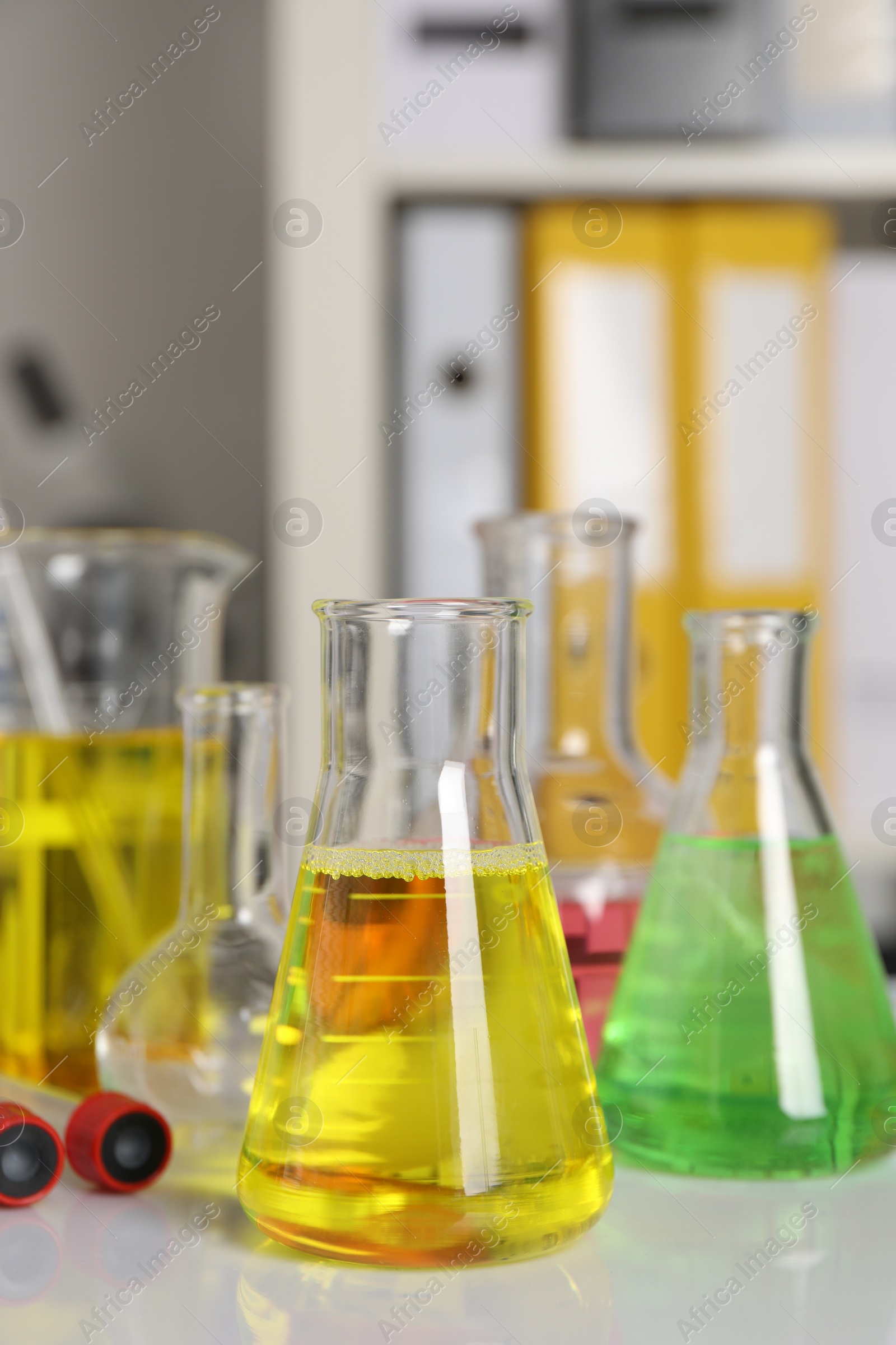 Photo of Laboratory analysis. Different glassware with liquids on white table indoors