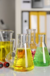 Laboratory analysis. Different glassware with liquids on white table indoors