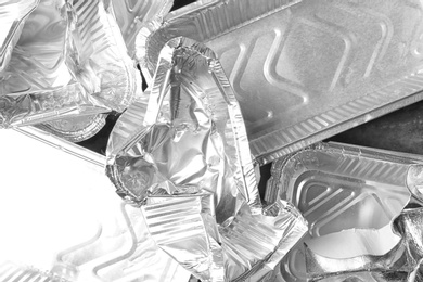 Pile of crumpled foil containers as background, top view. Recycling problem