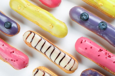 Photo of Delicious eclairs covered with glaze on white background, top view