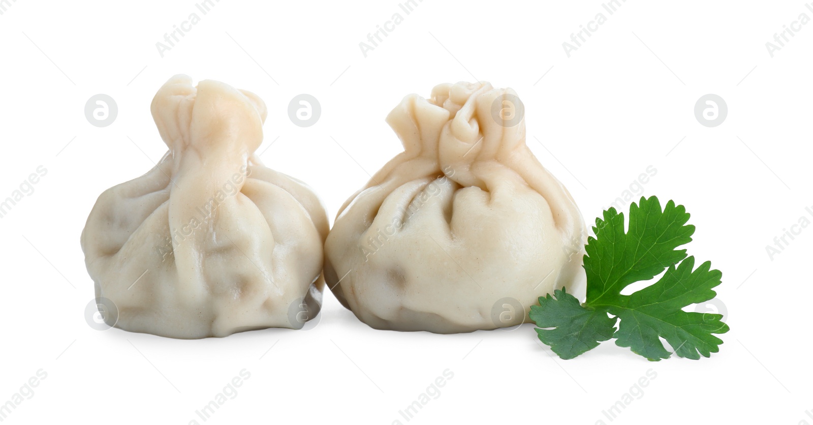 Photo of Two tasty khinkali (dumplings) and parsley isolated on white. Georgian cuisine