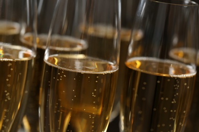 Many glasses of champagne as background, closeup view