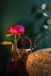 Vase with flower and interior elements near turquoise wall