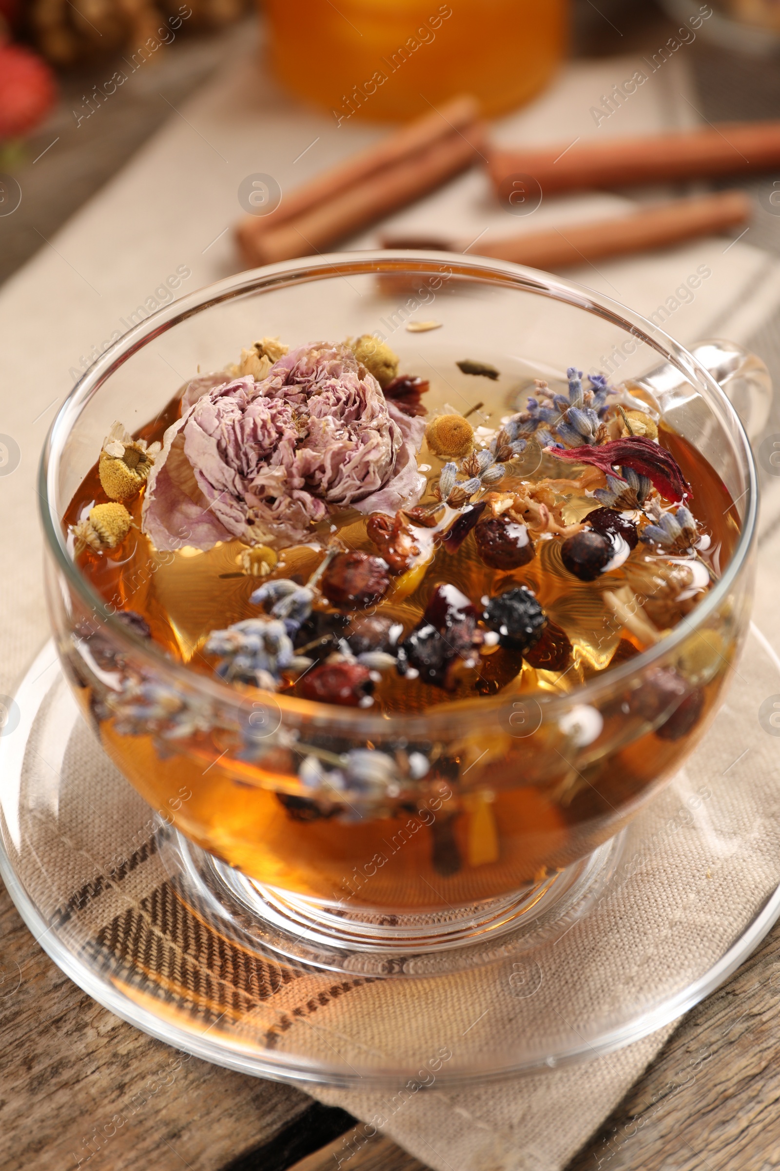 Photo of Aromatic tea with different dry herbs and flowers on wooden table, closeup