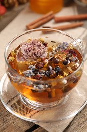 Aromatic tea with different dry herbs and flowers on wooden table, closeup