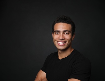 Photo of Handsome young African-American man on black background