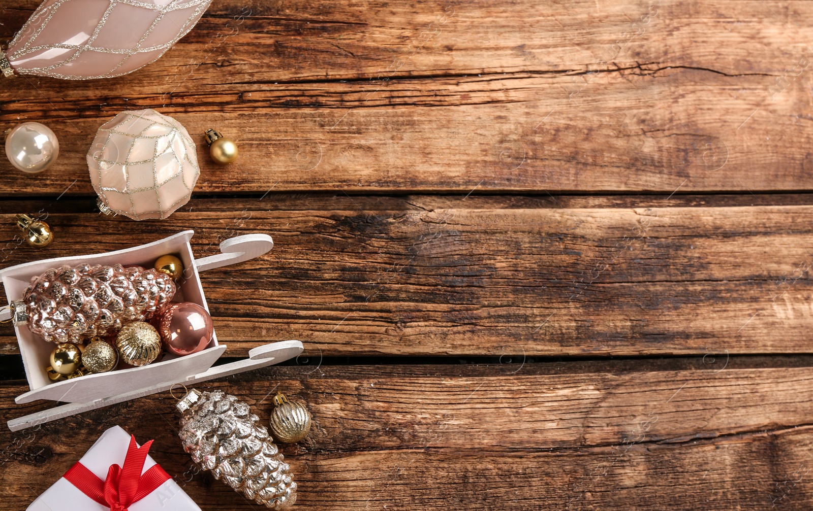 Photo of Beautiful Christmas composition with miniature sleigh on wooden table, flat lay. Space for text