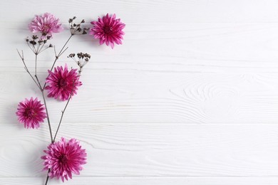 Photo of Flat lay composition with beautiful flowers a on white wooden table, space for text