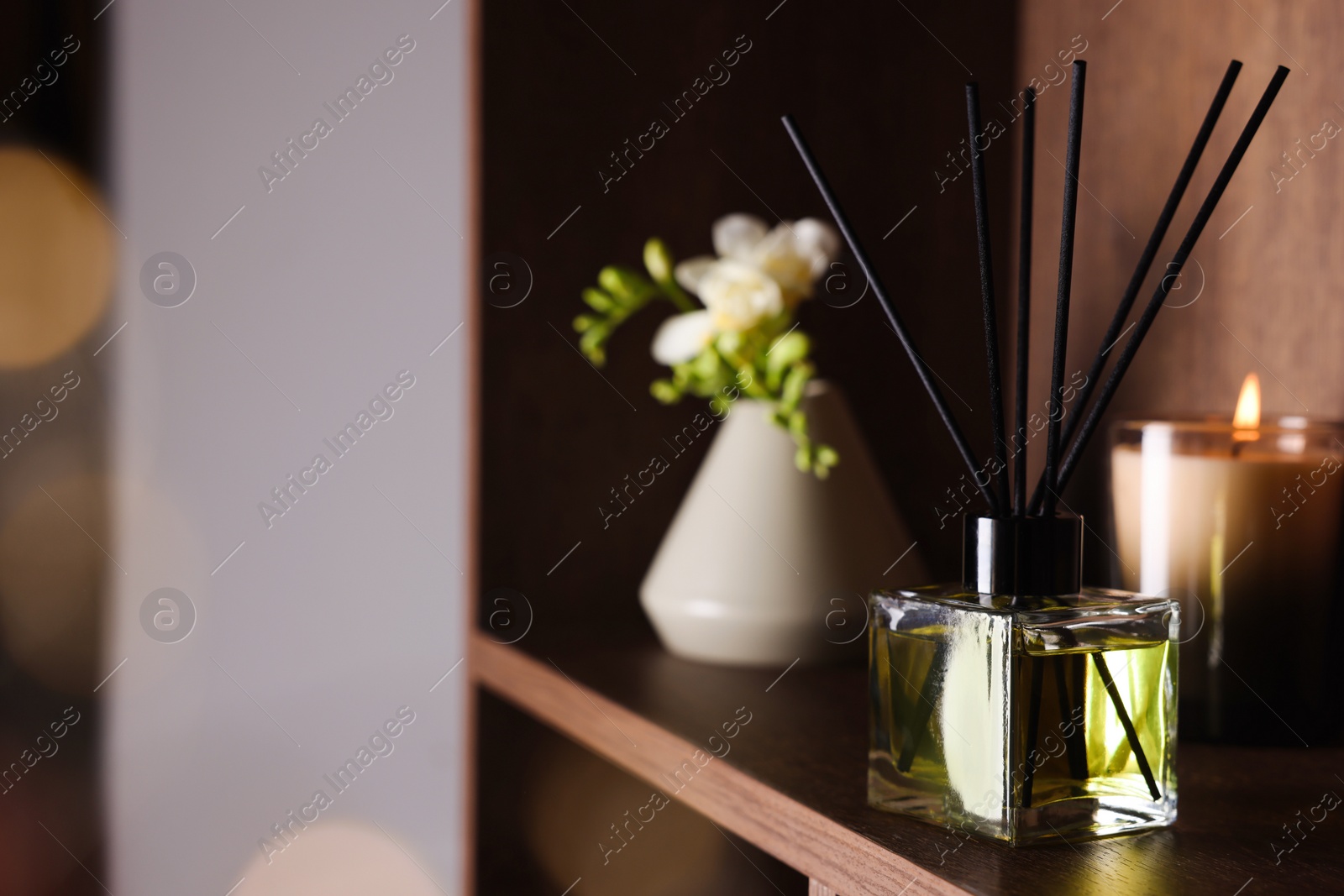 Photo of Aromatic reed air freshener on wooden shelf, space for text