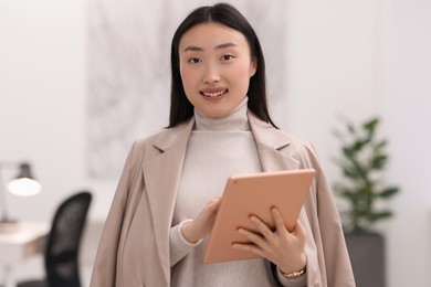 Portrait of smiling businesswoman with tablet in office