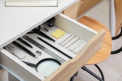 Office supplies in open desk drawer indoors, closeup