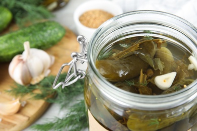 Photo of Jar with pickled cucumbers and products, closeup view