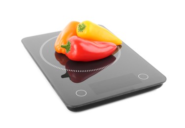 Photo of Heap of ripe bell peppers on kitchen scales against white background
