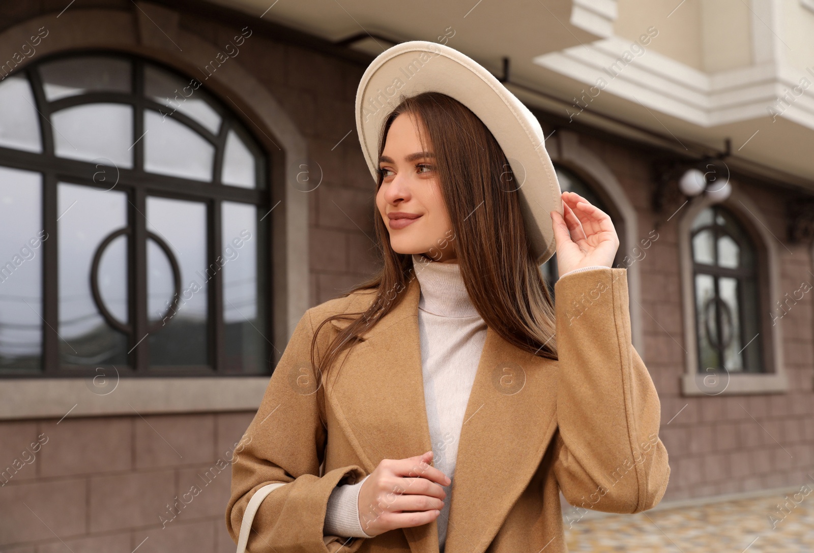 Photo of Beautiful young woman wearing stylish autumn clothes on city street