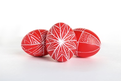 Creative painted red Easter eggs on white background