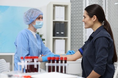 Photo of Laboratory testing. Doctor taking blood sample from patient at table in hospital