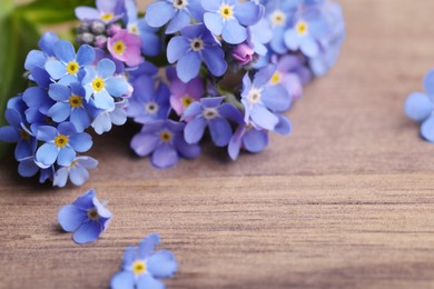 Photo of Beautiful blue Forget-me-not flowers on wooden table, closeup