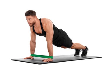 Photo of Young man exercising with elastic resistance band on fitness mat against white background