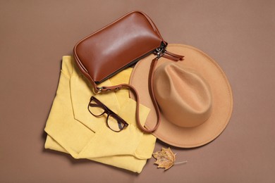 Photo of Flat lay composition with stylish hat on brown background