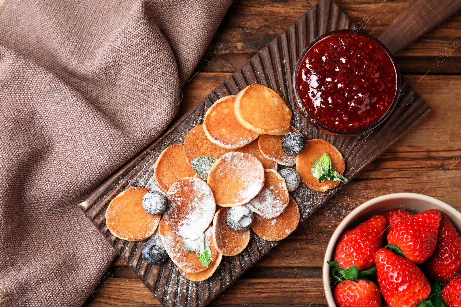 Photo of Cereal pancakes with jam and berries on wooden table, flat lay