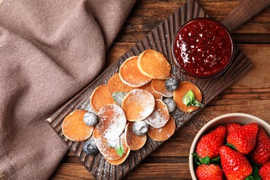 Cereal pancakes with jam and berries on wooden table, flat lay