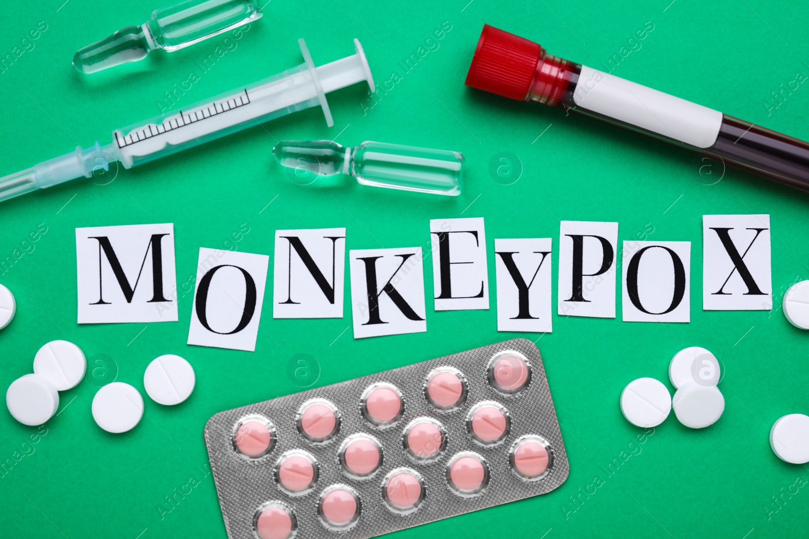 Photo of Flat lay composition with word Monkeypox and medical supplies on green background