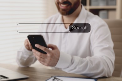 Image of Search bar of website over smartphone. Man using device at table indoors, closeup
