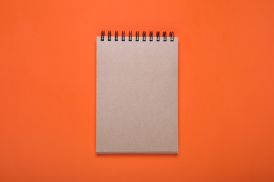 Photo of New office notebook on orange background, top view