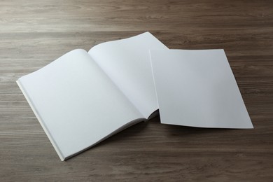Photo of Sheet of paper and blank brochure on wooden table. Mockup for design
