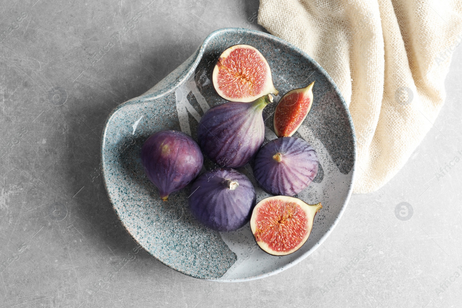 Photo of Plate with fresh ripe figs on gray background, top view