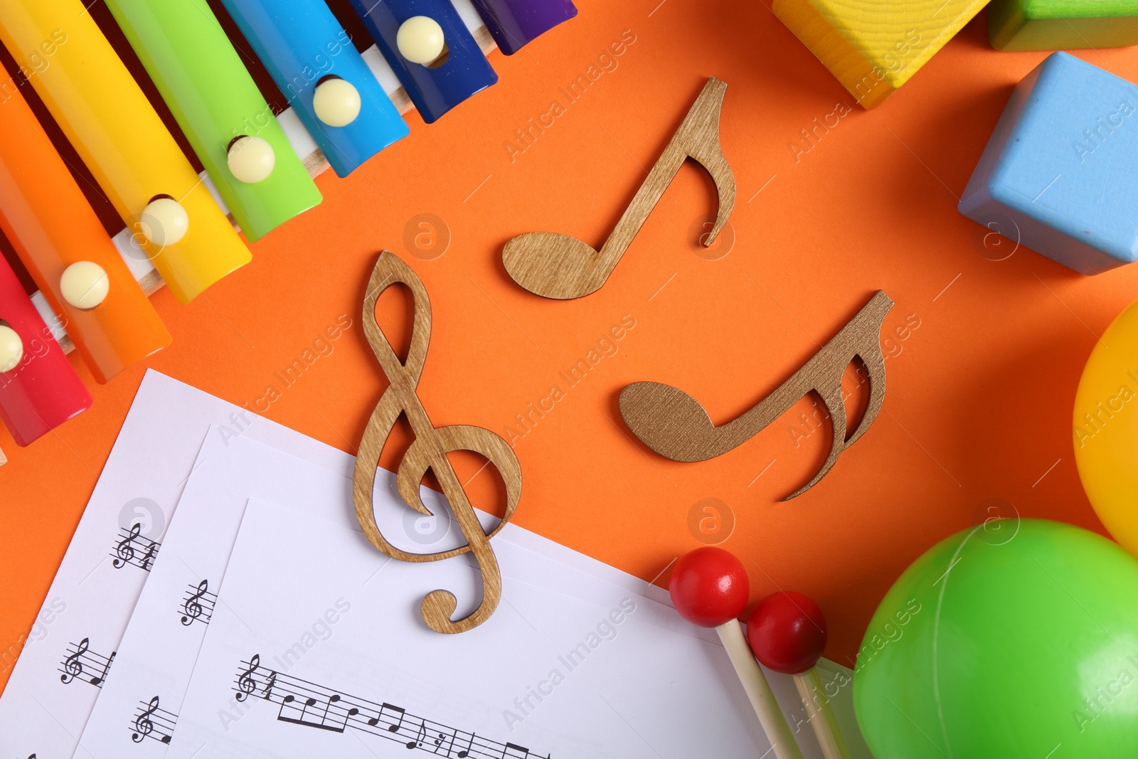 Photo of Creating baby songs. Flat lay composition with wooden notes on orange background