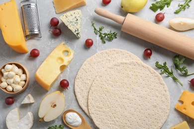 Photo of Flat lay composition with pizza crusts and fresh ingredients on marble table