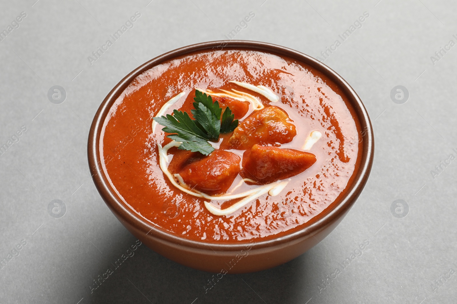 Photo of Bowl of delicious butter chicken on color background. Traditional indian Murgh Makhani