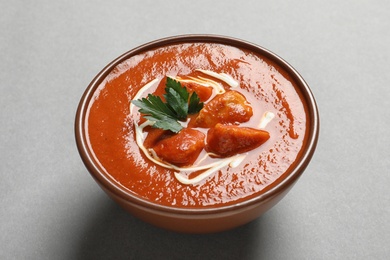Bowl of delicious butter chicken on color background. Traditional indian Murgh Makhani