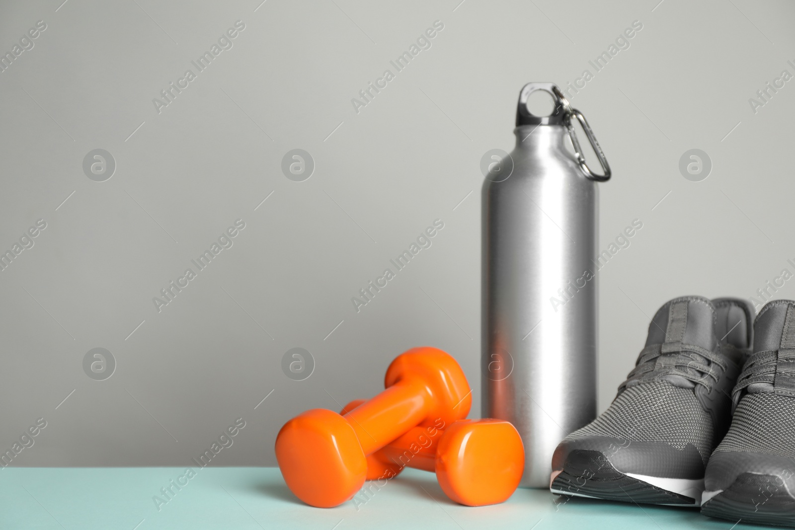 Photo of Composition with fitness equipment on light table, space for text